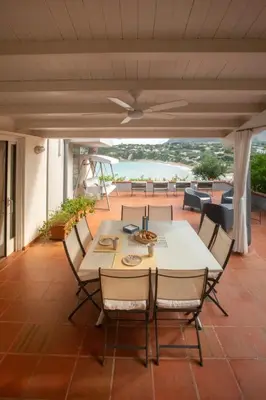 a table and chairs on a patio with a view of the ocean at La casa del Rinoceronte - Scopello, con accesso diretto al mare in Castellammare del Golfo
