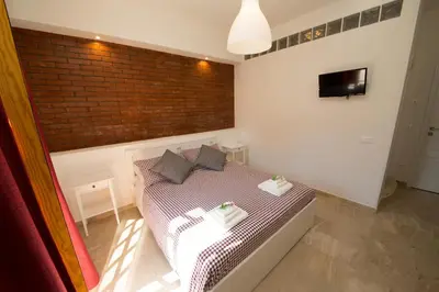a bedroom with a bed and a brick wall at La Balestra B&B in Balestrate