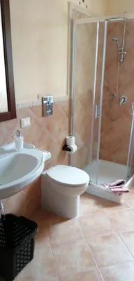 a bathroom with a shower and a toilet and a sink at Baglio delle Rondini in Bagheria