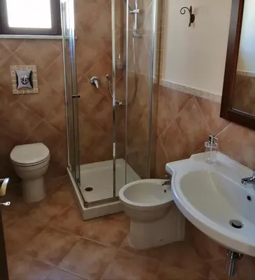 a bathroom with a shower and a toilet and a sink at Baglio delle Rondini in Bagheria