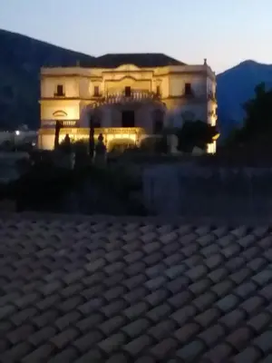 a large building in front of a house at Baglio delle Rondini in Bagheria