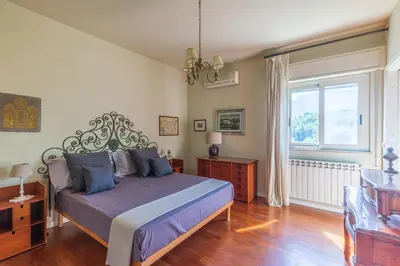 a bedroom with a large bed and a window at Domus Sicily - Villa Conca d'Oro with Pool in Palermo