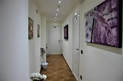 a hallway with a toilet and paintings on the walls at B&B Alexander-Room and Breakfast in Palermo
