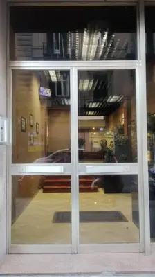 a glass door of a building with a reflection of a car at B&B Alexander-Room and Breakfast in Palermo