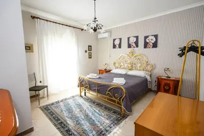 a bedroom with a king sized bed and a table at B&B Chiaro di Luna in Corleone
