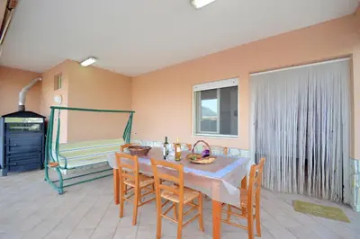 a dining room with a table with chairs and a bench at Villa Stella Cinese in Alcamo