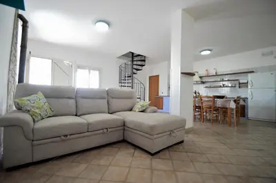 a living room with a couch and a kitchen at Villa Stella Cinese in Alcamo