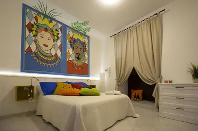 a bedroom with a bed with a painting on the wall at Casuzza Ballarò in Palermo