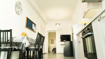 a kitchen with a table and a clock on a wall at Il Nido del Gabbiano in Bagheria