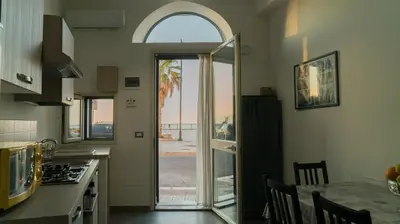 a kitchen with an open door to a patio at Il Nido del Gabbiano in Bagheria