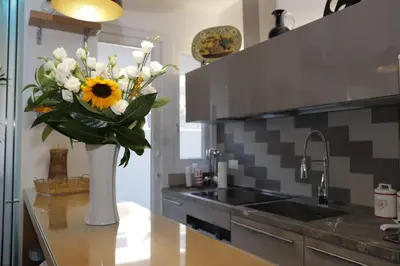 a vase of flowers on a counter in a kitchen at Maison Heloise in Palermo