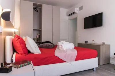 a bedroom with a red bed and a television at Maison Heloise in Palermo