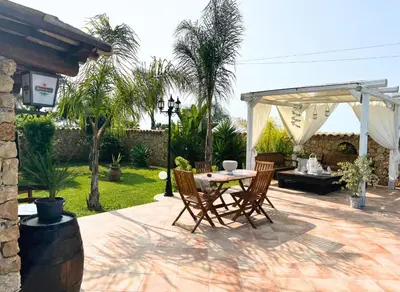 a patio with a table and chairs and a pergola at Case Vacanza Zeus in Trappeto