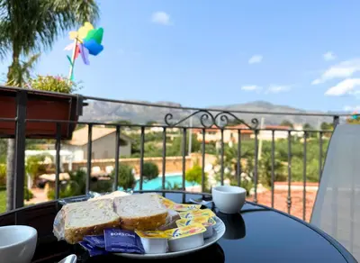 a table with a plate of sandwiches on a balcony at Case Vacanza Zeus in Trappeto