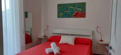a red bed with a white animal laying on it at Villetta a due passi dal mare in Palermo