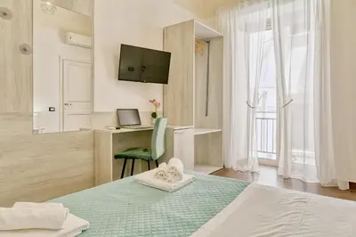 a bedroom with a bed and a desk and a television at Pupi 93 in Palermo