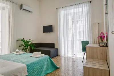 a white room with a bed and a couch at Pupi 93 in Palermo