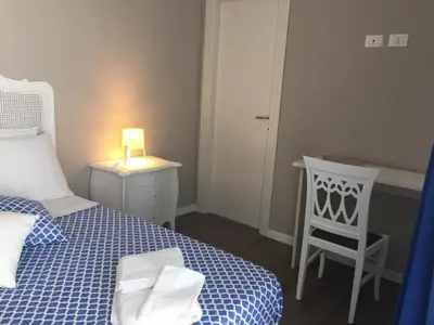 a bedroom with a bed and a table and a chair at THE VIEW in Palermo