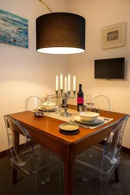 a dining room table with chairs and a light fixture at Cassàri Suite in Palermo
