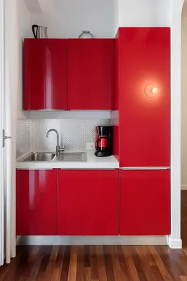 a kitchen with red cabinets and a sink at Cassàri Suite in Palermo