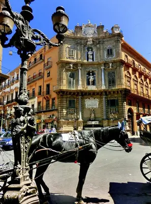 a statue of a horse pulling a carriage in front of a building at Normanni Homes in Palermo