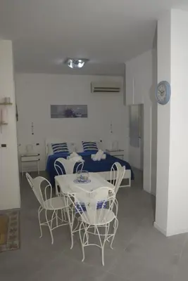 a room with a table and chairs and a bed at Normanni Homes in Palermo