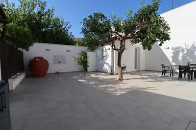 a courtyard with a table and a tree at La Casetta di Mondello in Mondello