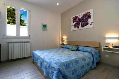 a bedroom with a bed and two windows at La Casetta di Mondello in Mondello