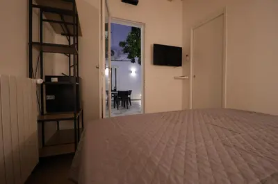 a bedroom with a bed and a room with a television at La Casetta di Mondello in Mondello