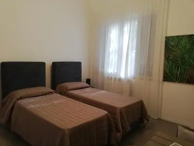 two beds in a hotel room with a window at Mondello Felix - appartamenti in villa a 600m dal mare in Mondello