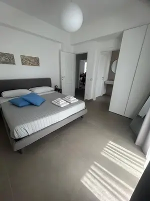 a bedroom with a bed with blue pillows on it at Mondello Felix - appartamenti in villa a 600m dal mare in Mondello