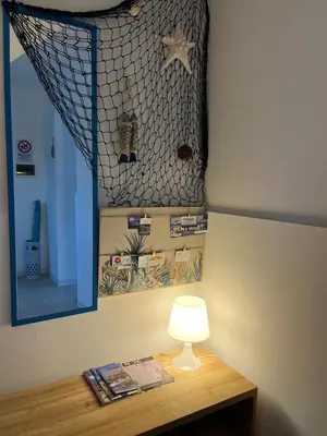 a table with a lamp and a picture on the wall at Xenia House in Lascari