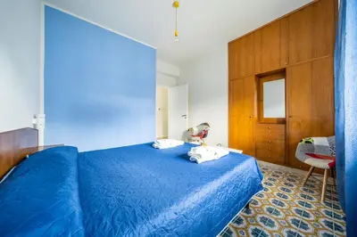 a bedroom with a blue bed and a wooden cabinet at La Maison De Provence - MONDELLO in Mondello