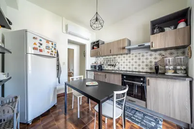 a kitchen with a black table and a refrigerator at La Maison De Provence - MONDELLO in Mondello