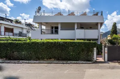 a white house with a hedge in front of it at La Maison De Provence - MONDELLO in Mondello
