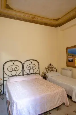 a bedroom with two beds and a mirror on the wall at ERCTA in Palermo