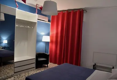 a bedroom with a red curtain and a mirror at Casa Rosetta in Palermo