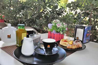 a table with two plates of food and coffee cups at Casa Rosetta in Palermo