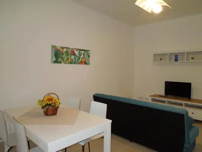 a living room with a white table and a blue couch at Mondello Rose House in Palermo