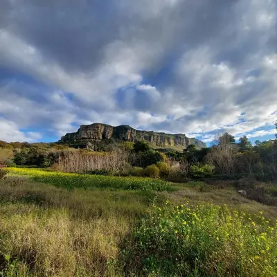 a grassy field with a mountain in the background at Chiosi Country Club in Corleone