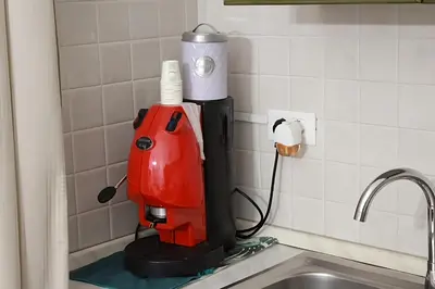 a red mixer sitting on a counter next to a sink at casa salusa in Terrasini