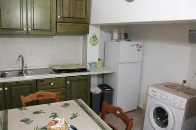a kitchen with a table and a white refrigerator at casa salusa in Terrasini