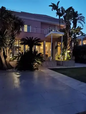 a house with palm trees in front of it at Villa Olimpia in Mondello
