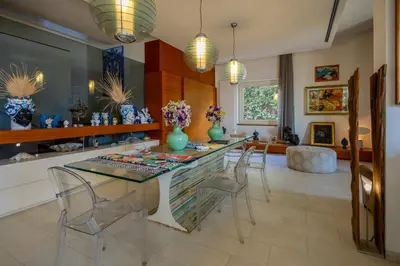 a living room with a table and a tv at Villa Olimpia in Mondello