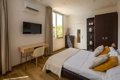 a bedroom with a bed and a desk and a television at Villa Olimpia in Mondello