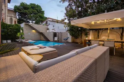 a patio with two lounge chairs and a swimming pool at Villa Olimpia in Mondello