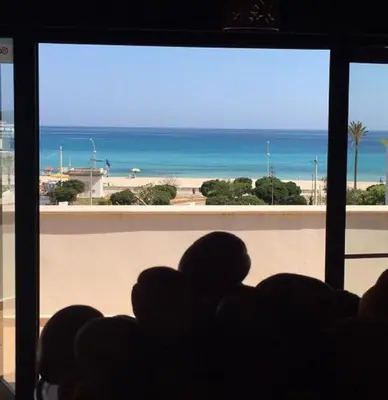 a room with a view of the beach from a window at Hotel Baia Di Venere in San Vito lo Capo