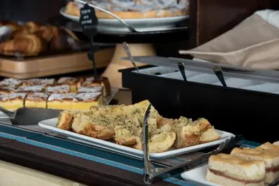 a plate of bread and other pastries on a counter at Hotel Baia Di Venere in San Vito lo Capo