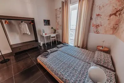 a bedroom with a bed and a table and a window at casaDamare in Palermo