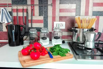 a kitchen counter with tomatoes and vegetables on a cutting board at casaDamare in Palermo